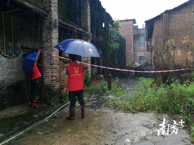 黨群志愿者冒雨拉起警戒線。