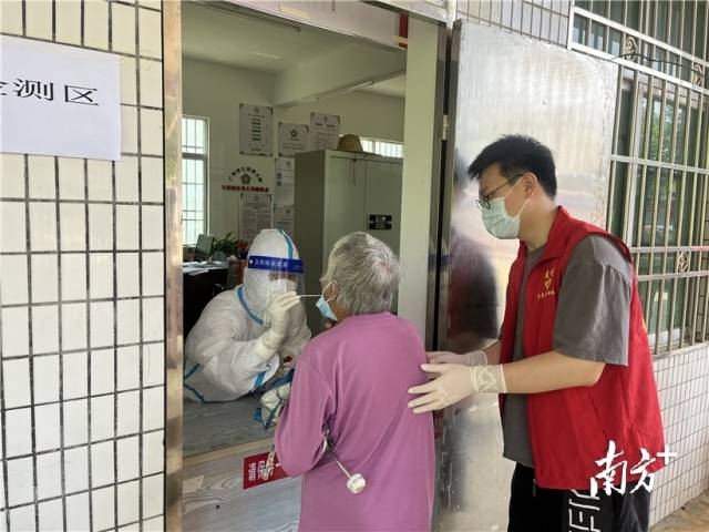 現(xiàn)場(chǎng)志愿者幫助行動(dòng)不便群眾接受核酸檢測(cè)。